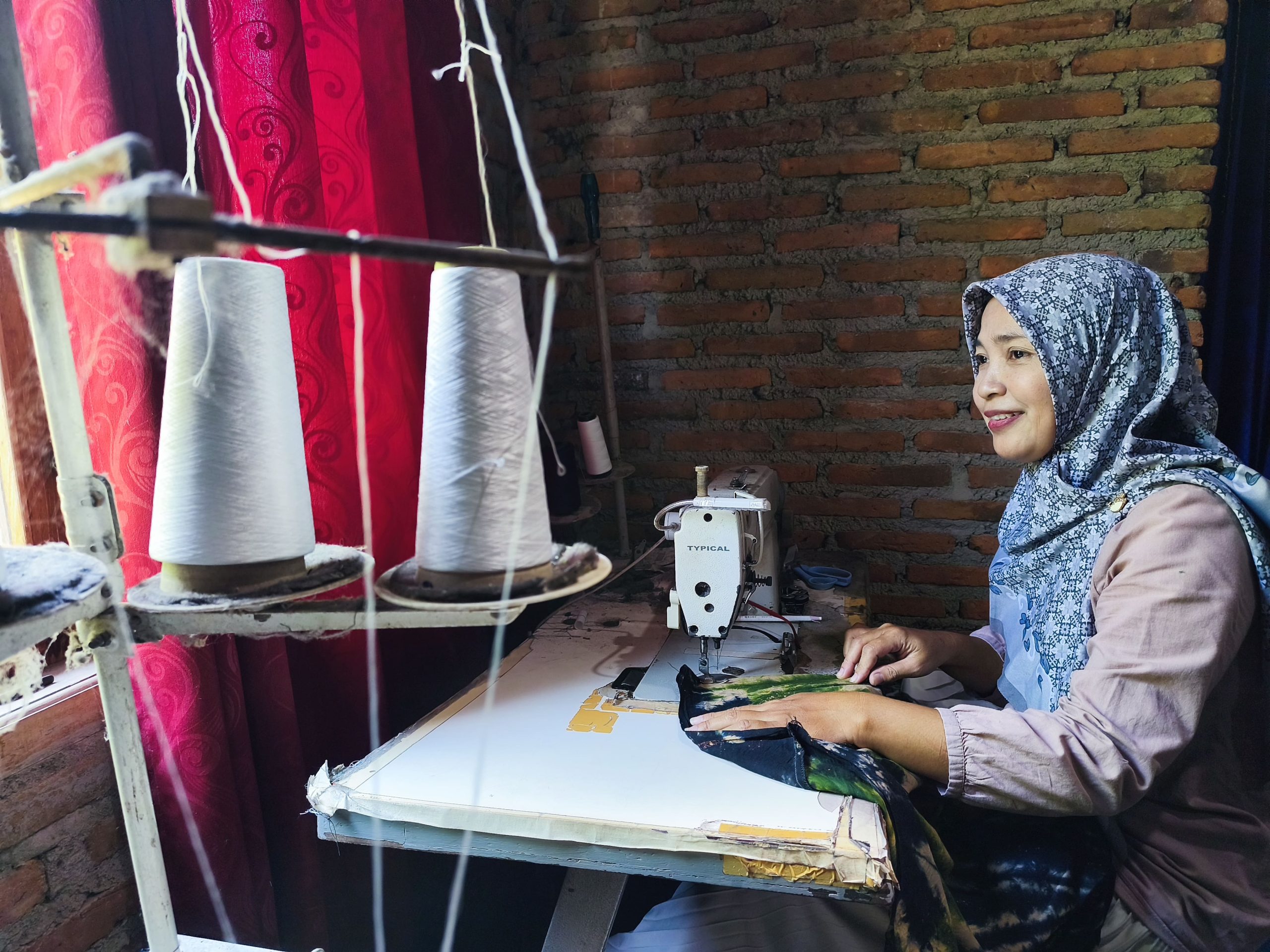 Suprapti di depan meja jahitnya. (Foto: I.K Nino Sativara/SPEK-HAM)